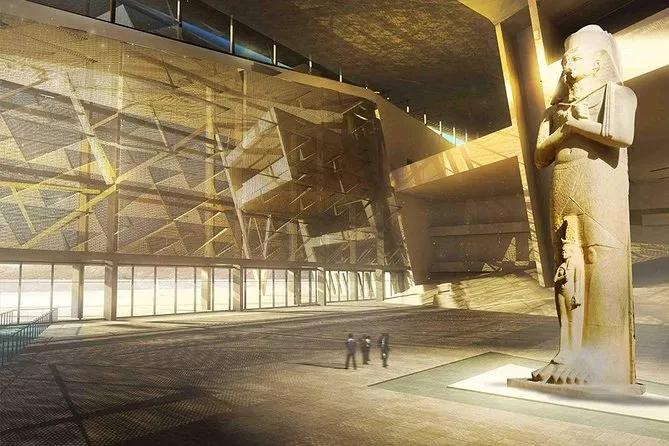 Colossal statue of Ramses II in the Grand Egyptian Museum atrium, featuring modern architecture and natural sunlight.