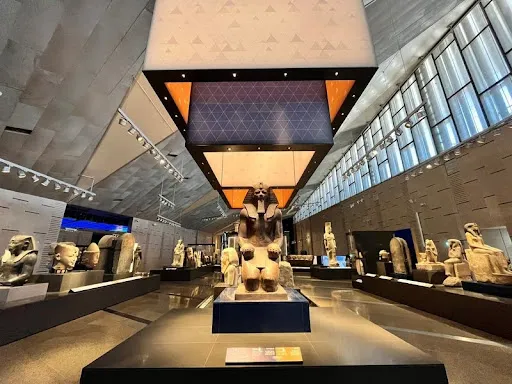 Pharaonic statues at Grand Egyptian Museum showcasing the blend of ancient heritage with immersive Virtual Experiences and digital tech.
